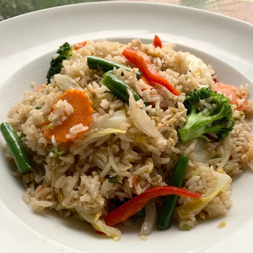 Close-up of Thai fried rice with broccoli, carrots, green beans, and red bell peppers.